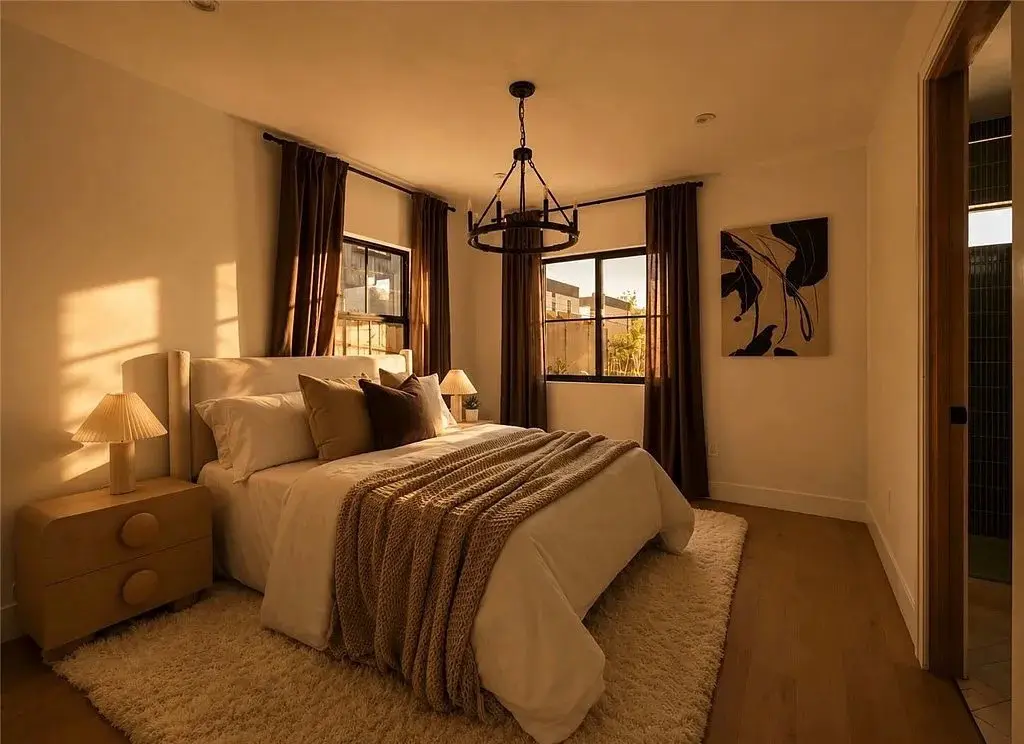 Echo Park home staging primary bedroom with neutral bedding and warm brown curtains